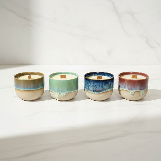 Four ceramic wood wick candles with different color glazes on a white surface. Beeswax & Coconut Wax - CocoBee.