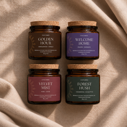 Four CocoBee Sunset Ritual candles in amber-glass jars with cork lids, arranged on soft beige fabric: Golden Hour, Welcome Home, Velvet Mist and Forest Hush.