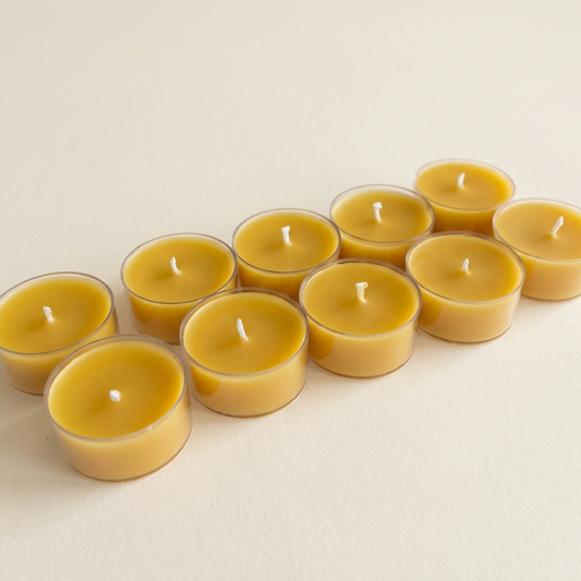 Row of beeswax candles on a beige background