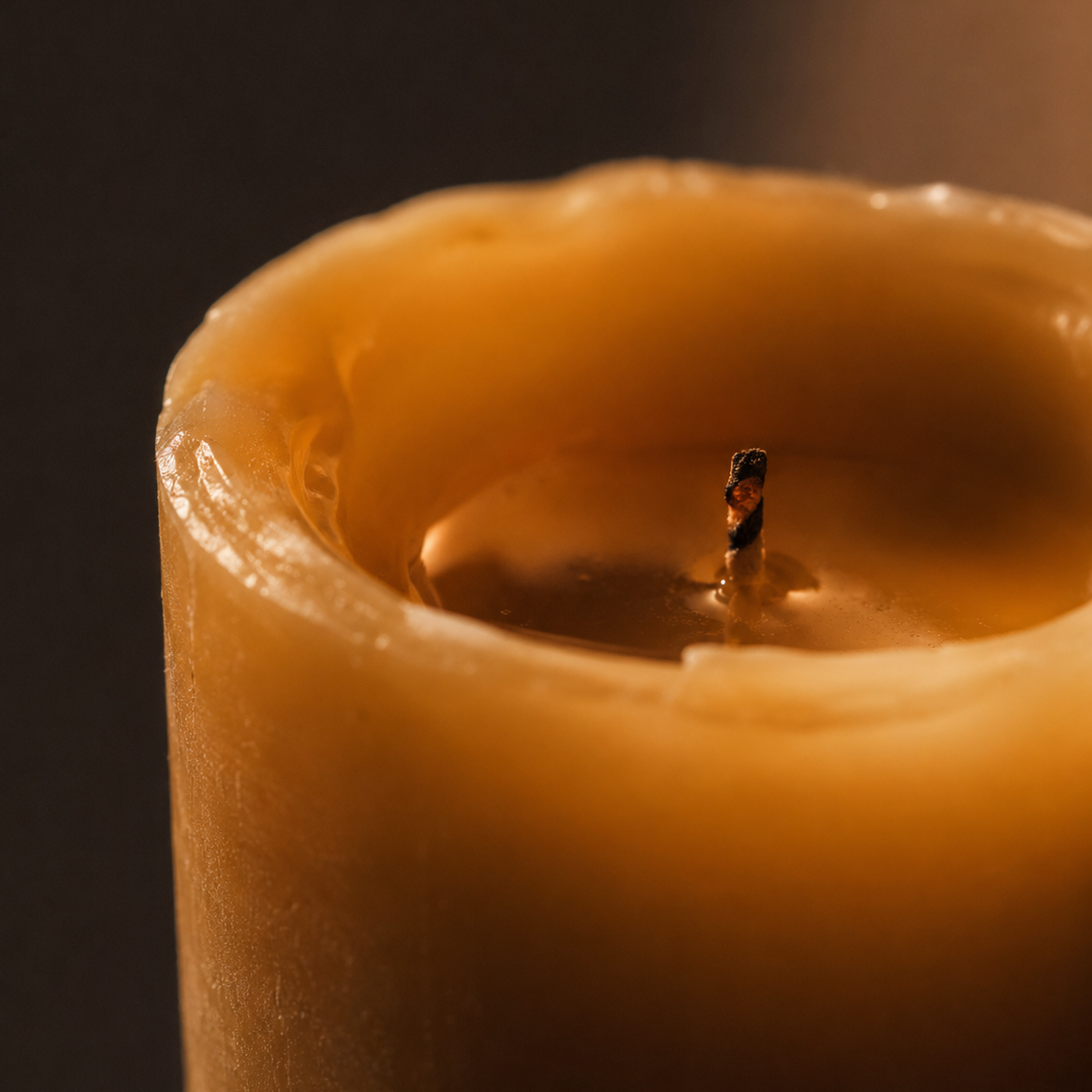 Close-up of a lit candle with a dark background